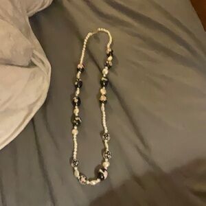 A pearl necklace with flower 3-D art on the inside of the bead